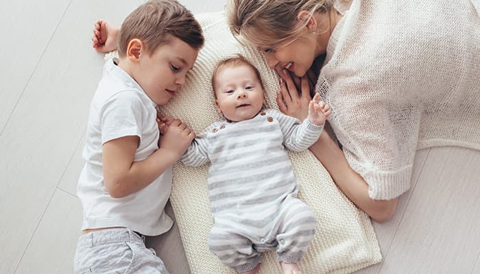 Young mom with her 5 years old son and 2 month old baby